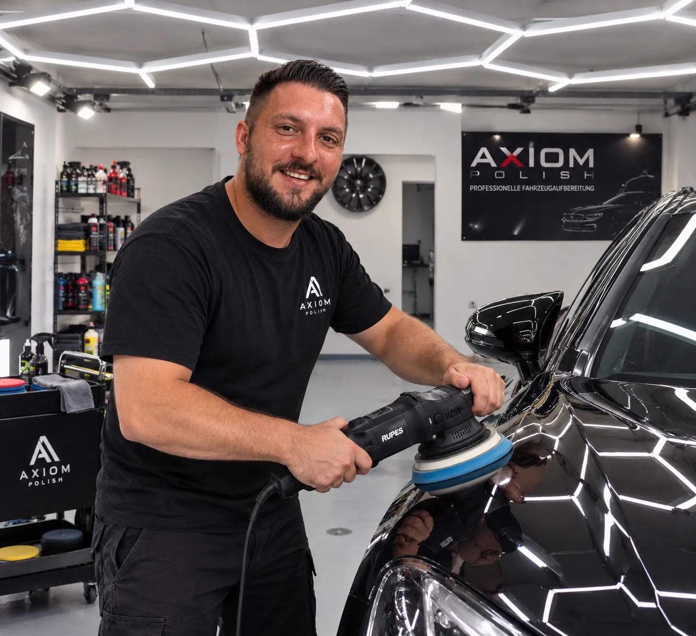 Florent Musliu poliert einen schwarzen BMW in der Werkstatt in Schaan